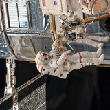 Astronauts repairing the Hubble Space Telescope