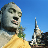 Statue of Buddha with a temple in the background