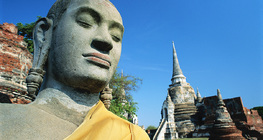 Statue of Buddha with a temple in the background